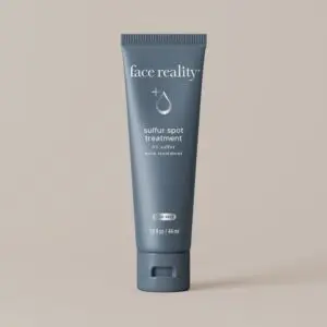 White background with a tube of face reality sulfur spot treatment, which is a cream-colored tube with text on it